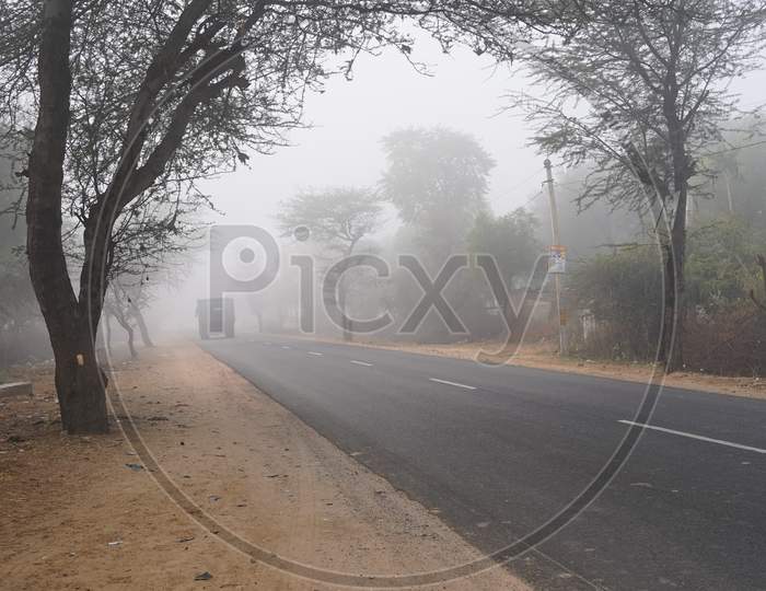 Rural Asphalt Highway View With Attractive Winter Season Morning. Vehicles Passing Through Fog.