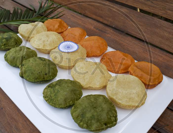 India Tricolor / Tricolour Food Breakfast Of Spinach Puri, Carrot Puri, And Plain Puri. Concept For Indian Republic Day Celebration On 26 January With Ashoka Chakra.