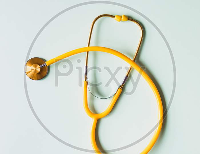 yellow stethoscope on white background