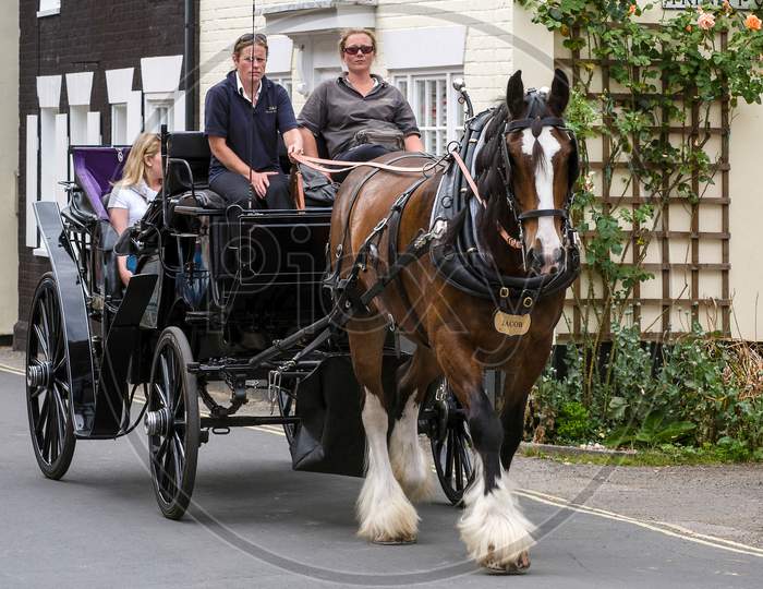 People Enjoying A Horse And Carriage Ride Through Southwold