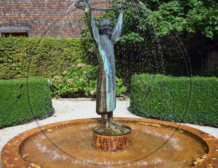 Statue Of A Man Holding A Hoop Fountain In St Gilgen