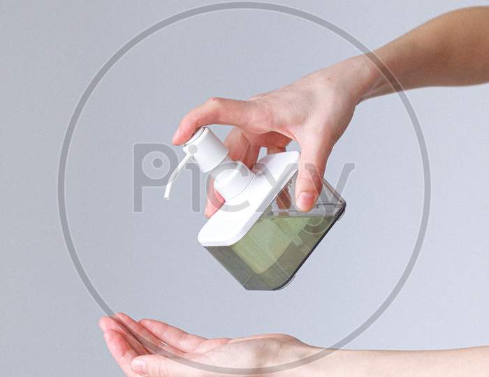 woman taking sanitizer in her hand