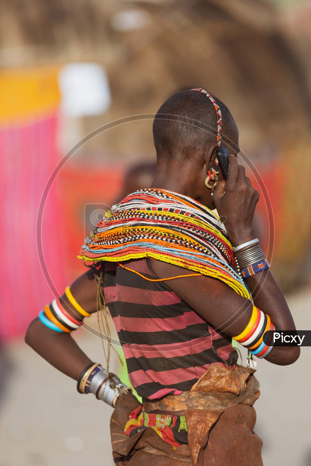 Turkana Woman Wearing The Hand Made Bead Traditional Jewerly Talking On The Phone