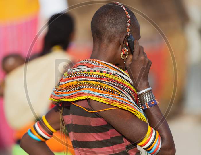 Turkana Woman Wearing The Hand Made Bead Traditional Jewerly Talking On The Phone