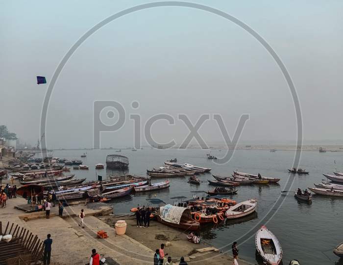 Boats at river Ganga Ghat people at holy ghats among ancient hindu temples in early morning in Varanasi Evening at Banaras Ghat
