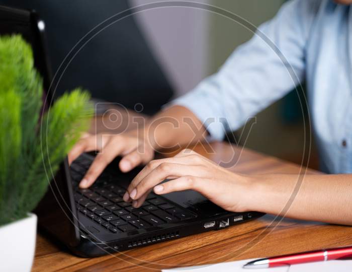 Close Up Of Unrecognisable Young Business Woman Working Or Typing On Laptop Keyboard At Table In Office.
