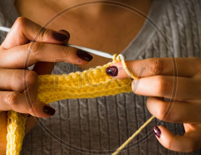 The Woman Knits Woolen Clothes. Knitting Needles.