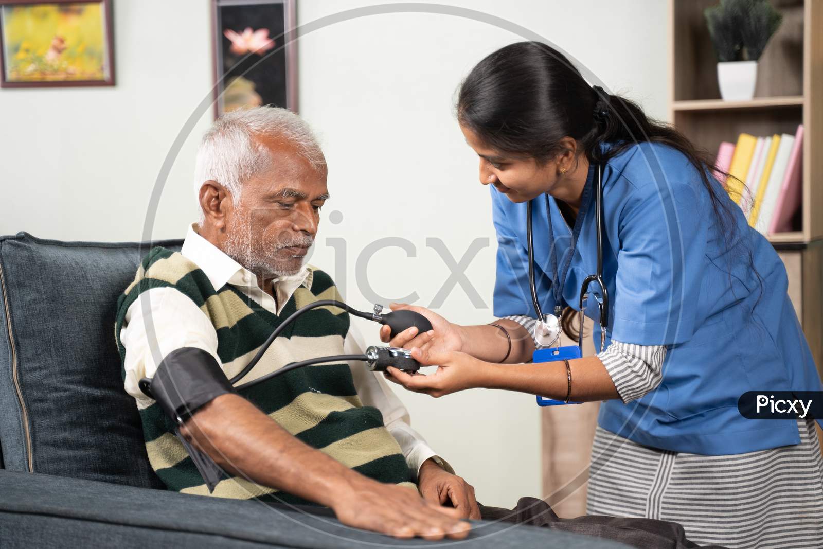 Doctor Or Nurse Checking Blood Pressure Or Bp Of Patient At Home - Concept Of Elderly People Routine Home Health Care Or Service.