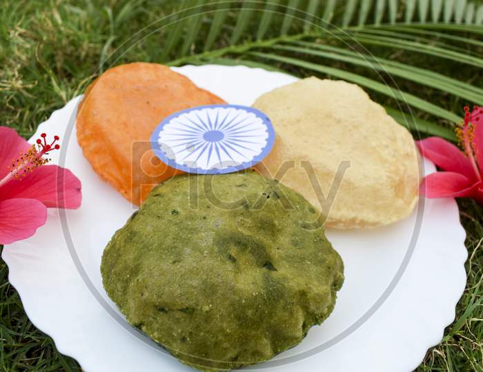 India Tricolor Tricolour Food Breakfast Of Spinach Puri, Carrot Puri, And Plain Puri. Concept For Indian Republic Day Celebration On 26 January With Ashoka Chakra.