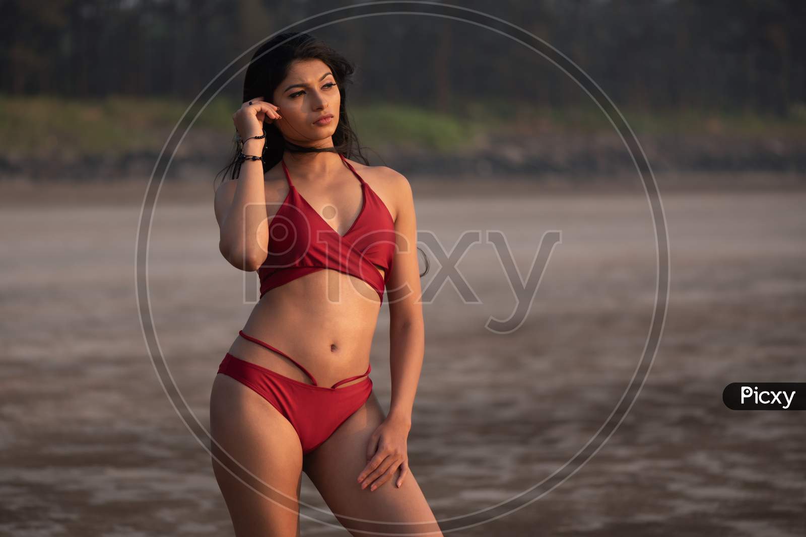 Young Indian girl in red bikini enjoying her vacation on beach and relaxing on beach