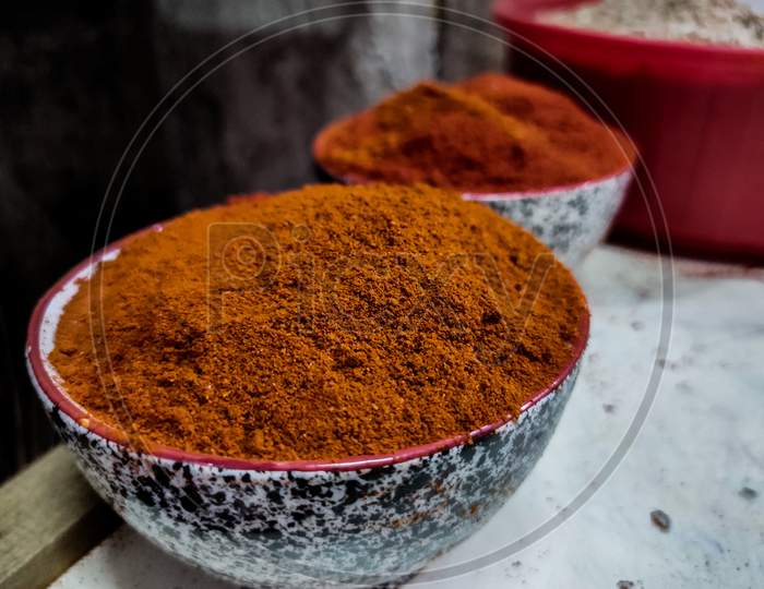 Pile Of Homemade Indian Garam Masala Or Curry Powder In Bowl On Blur Background.