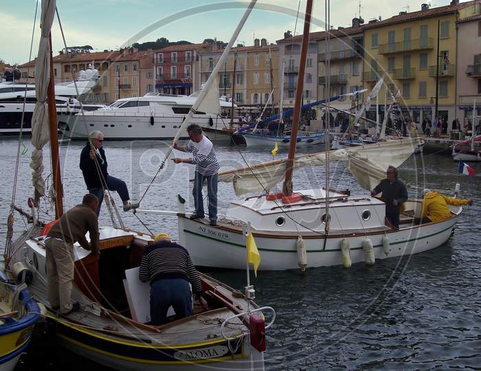 Saint Tropez, France - May 04th 2018: A german photographer visiting the french riviera, taking pictures of the contrast between the exclusive yachts and the small wooden fisher boats.