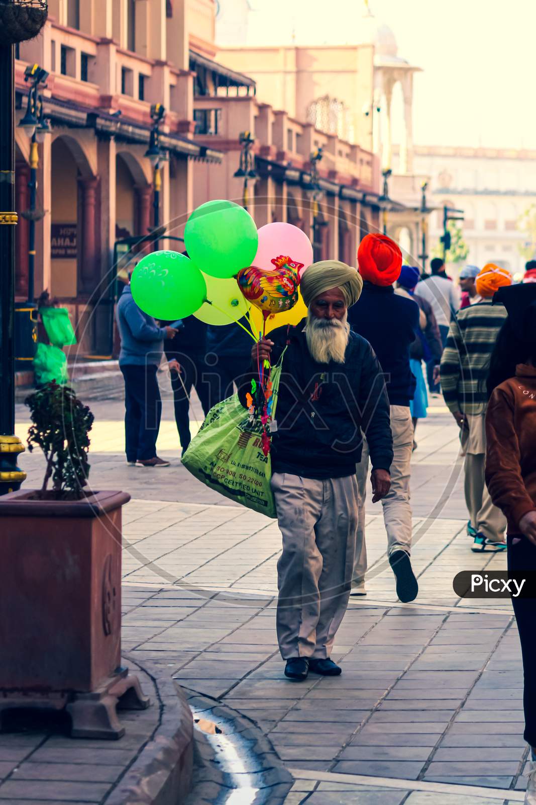 an old man selling balloons walking on the street