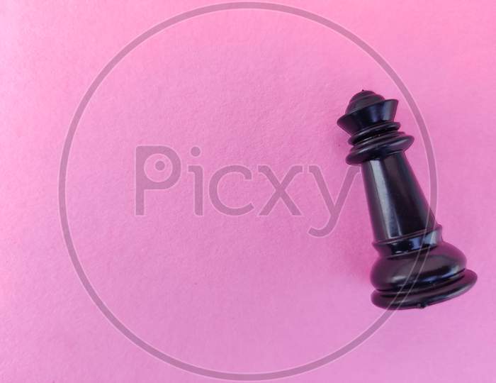 Copy Space Of Black Chess Queen Isolated On Pink Background.