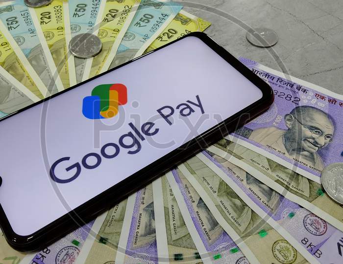 Tamil Nadu, India - January 21 2021: Indian currency notes along with new logo of Google pay on a smart phone