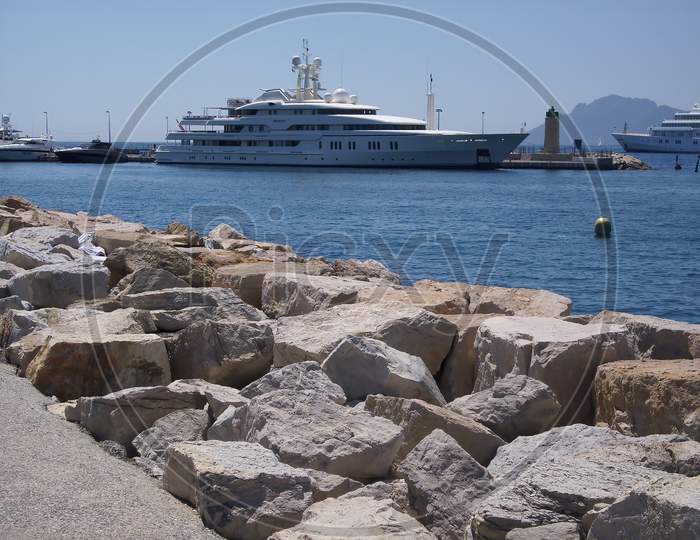 Cannes, France - 07th January 2018: A german photographer visiting the french riviera, taking pictures outside the harbor of Cannes with its expensive yachts.