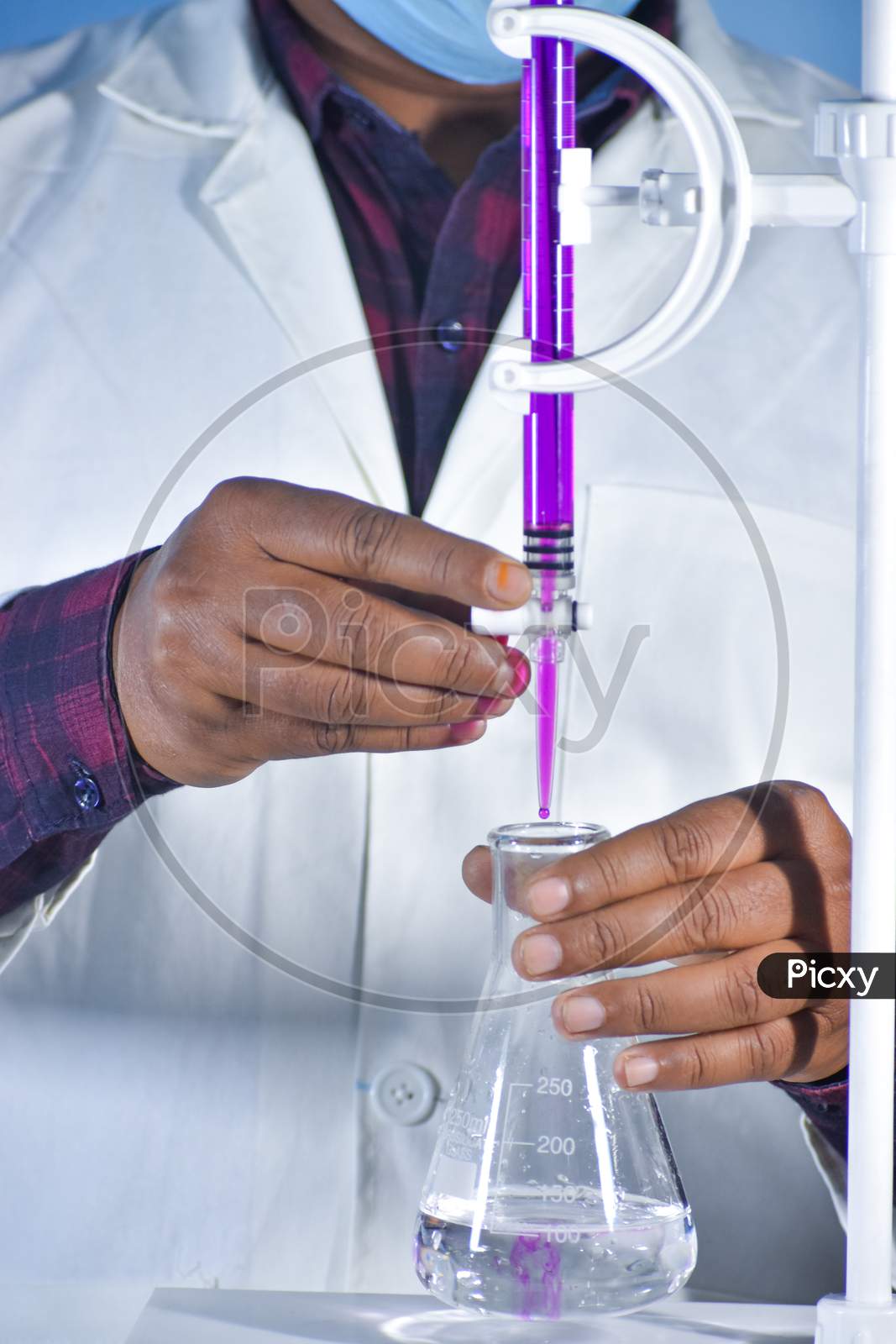 Scientist Performing Titration Experiment With Color Solution In Chemistry Lab