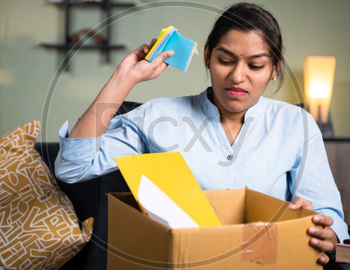Angry Business Woman Employee Throwing Sticky Notes Inside The Box Due To Loss Of Job, Fired, Laid Off Or Terminated From Company Without Warning.