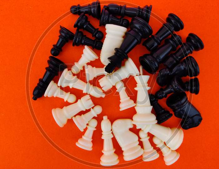 Top View Of Number Of Black And White Chess Pieces Isolated On Orange Background.