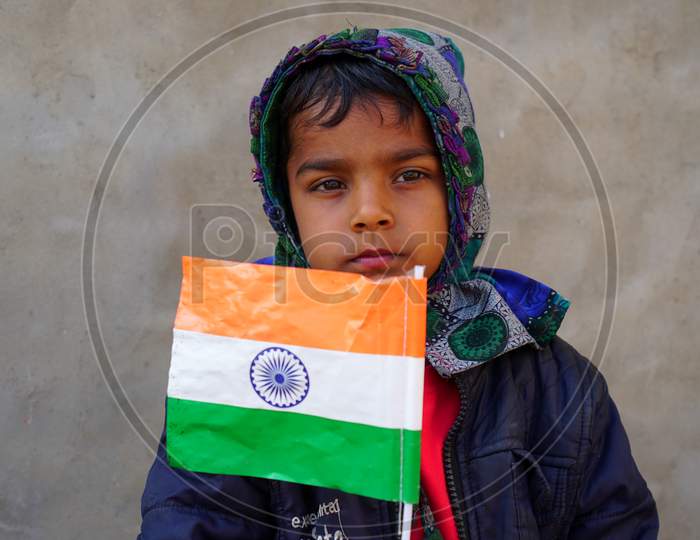 Cute Little Kid Holding The National Flag Of India. National Flag Or Tringa Closeup View On 72 Republic Day 2021.