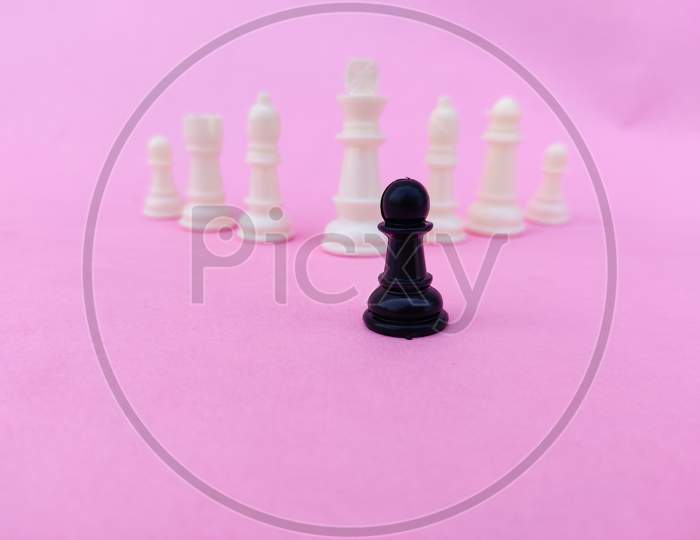 Black Chess Pawn Facing Mighty White Chess Pieces. Small Vs Big Business Competition Concept. Pink Background