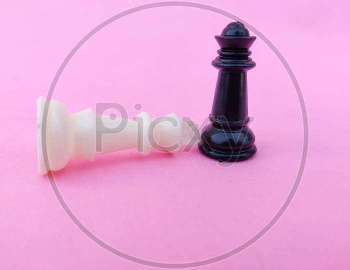 White Chess King Surrender To Black Chess Queen. Pink Background