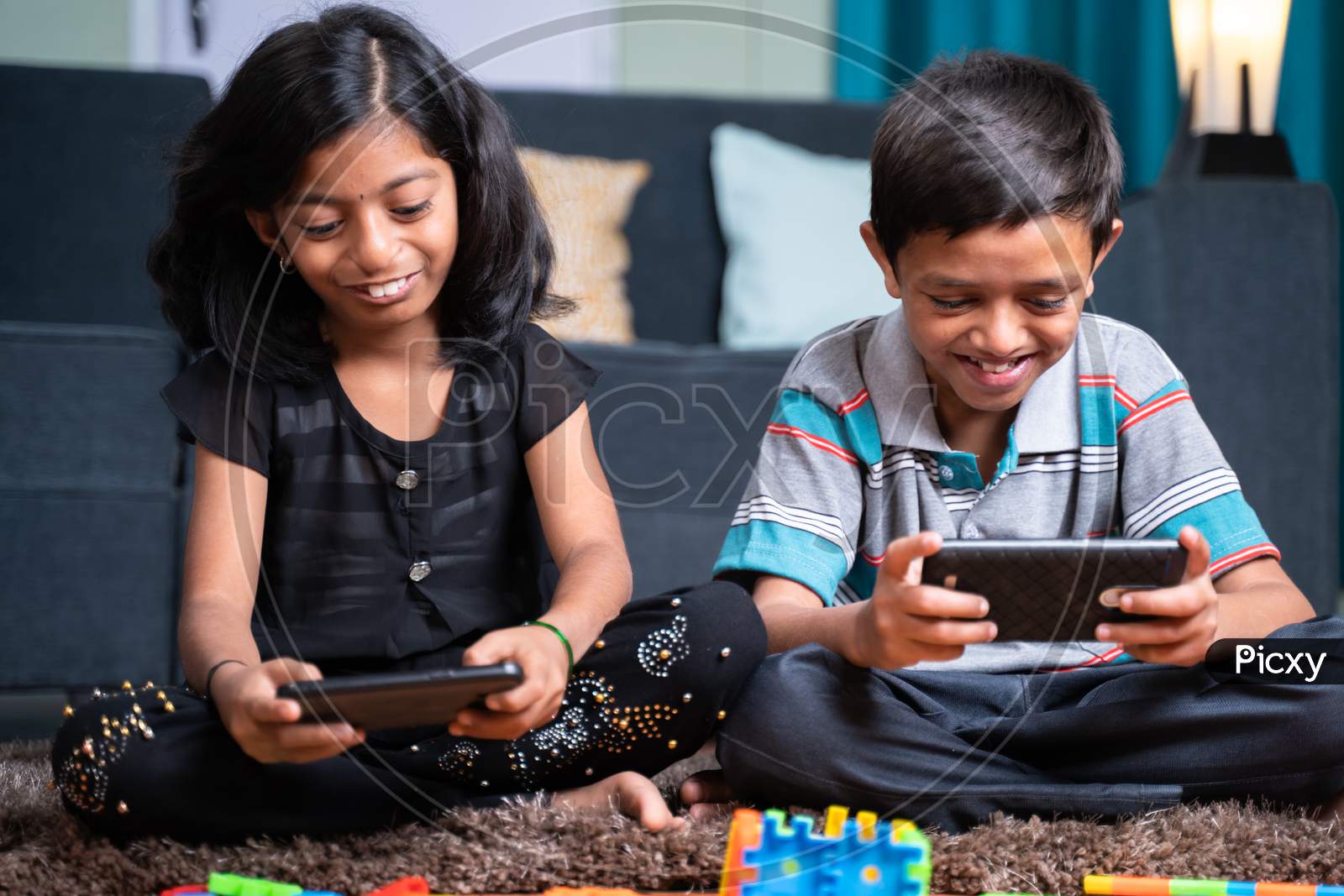Two Young Sibling Kids Playing Online Video Game On Mobile Phone At Home - Concept Of Smartphone Game Addiction. Holidays, Modern Technology Lifestyle.