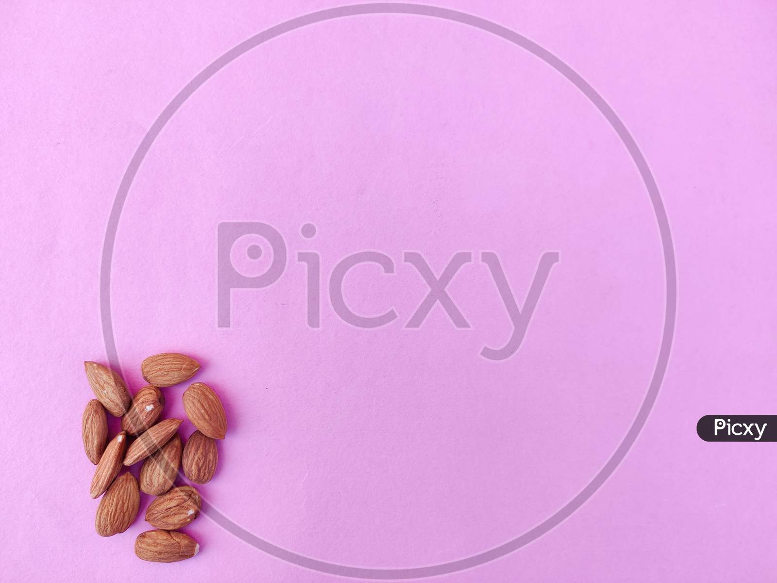 Copy Space Of Many Almonds In The Corner. Pink Background