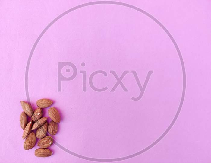 Copy Space Of Many Almonds In The Corner. Pink Background