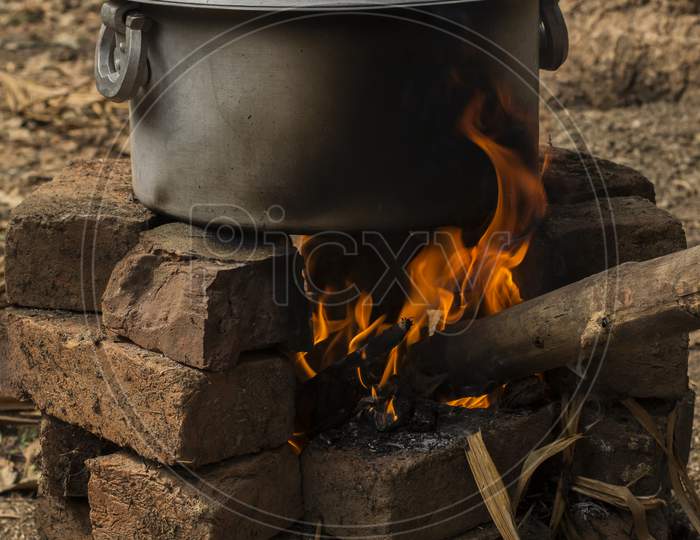 An Aluminum Utensil On A Temporarily Made Fire Oven By Bricks.