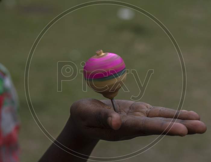 A Spinning Top Or Lattu In Hindi Spinning On A Hand.