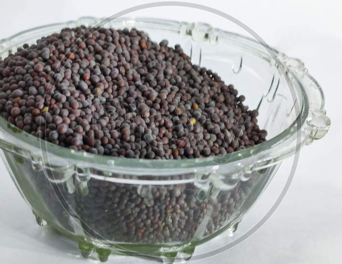 Mustard Seeds In Glass Bowl On A White Isolated Surface