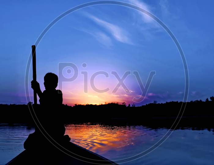 Silhoutte evening click of a fisherman in boat