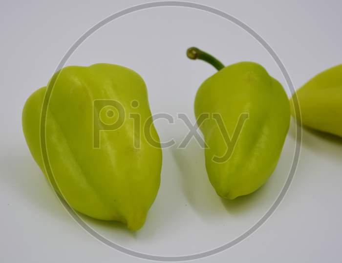 Fresh yellow and green bell peppers, not hot sad peppers are arranged on a white background. Vegetables that grow in Ukraine, healthy and wholesome food for every day.