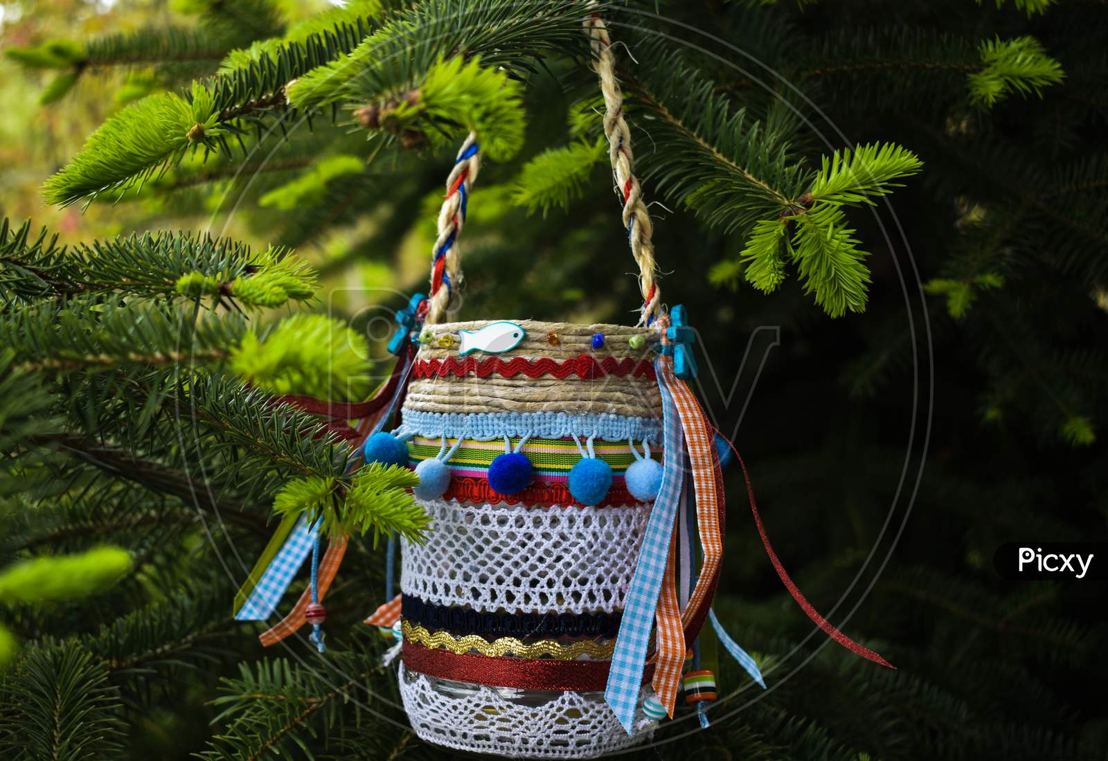 A Small Colorful Vase Hung On A Branch Of A Fir Tree