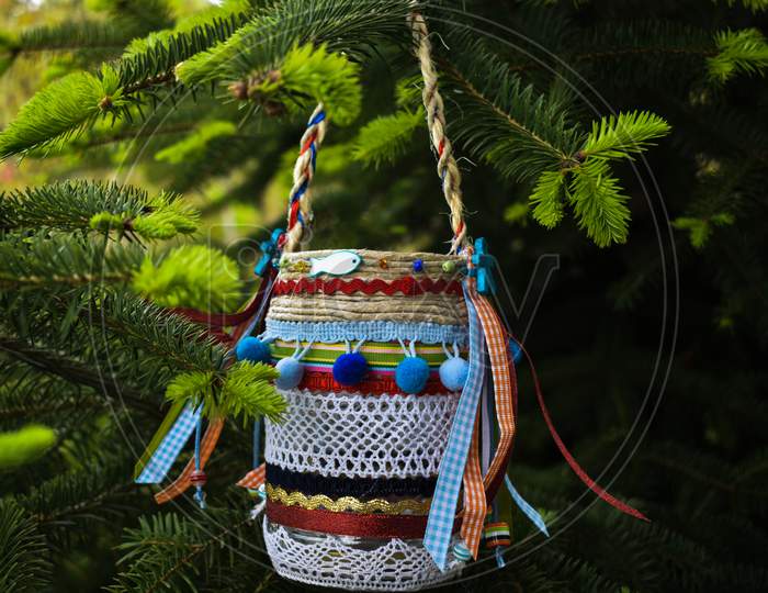 A Small Colorful Vase Hung On A Branch Of A Fir Tree