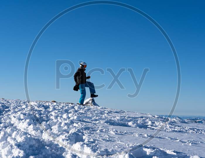Girl In Snowboard-Wear Is Funny Walking On Top Of A Mountain Peak In Hasliberg Switzerland