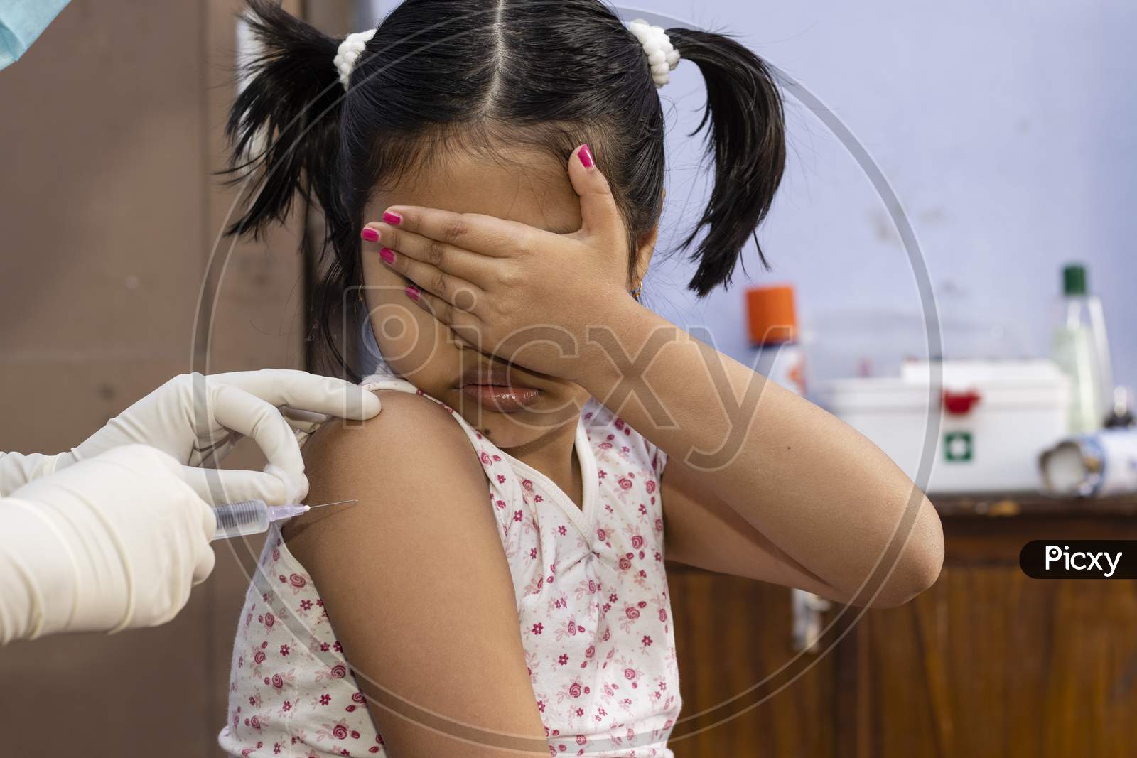 An Indian Girl Child Covers Her Eyes In Fear During Vaccination