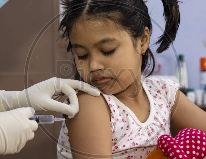 An Indian Girl Child Looks At The Needle During Vaccination