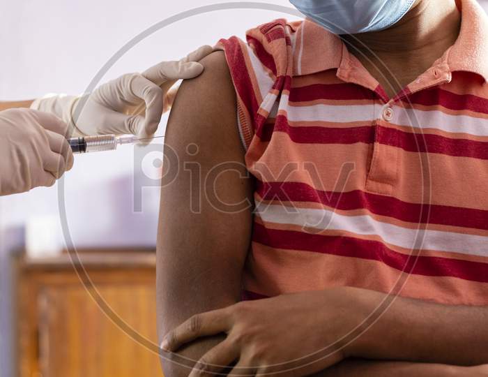 Hands With Injection Syringe For Vaccination To An Indian Male Person In Nose Mask