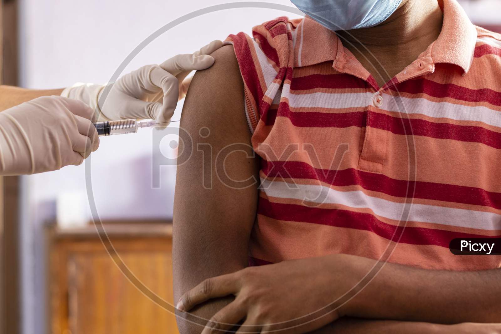 Hands With Injection Syringe For Vaccination To An Indian Male Person In Nose Mask
