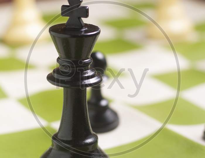 One Side Light On Black King Chess Piece. Close Up Photo