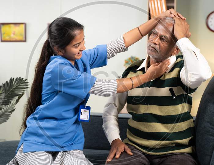 Doctor Or Physician Nurse Helping Senior Man For Neck Exercise By Rotating Patients Head At Home - Concept Of Elderly People Home Health Care Or Service.