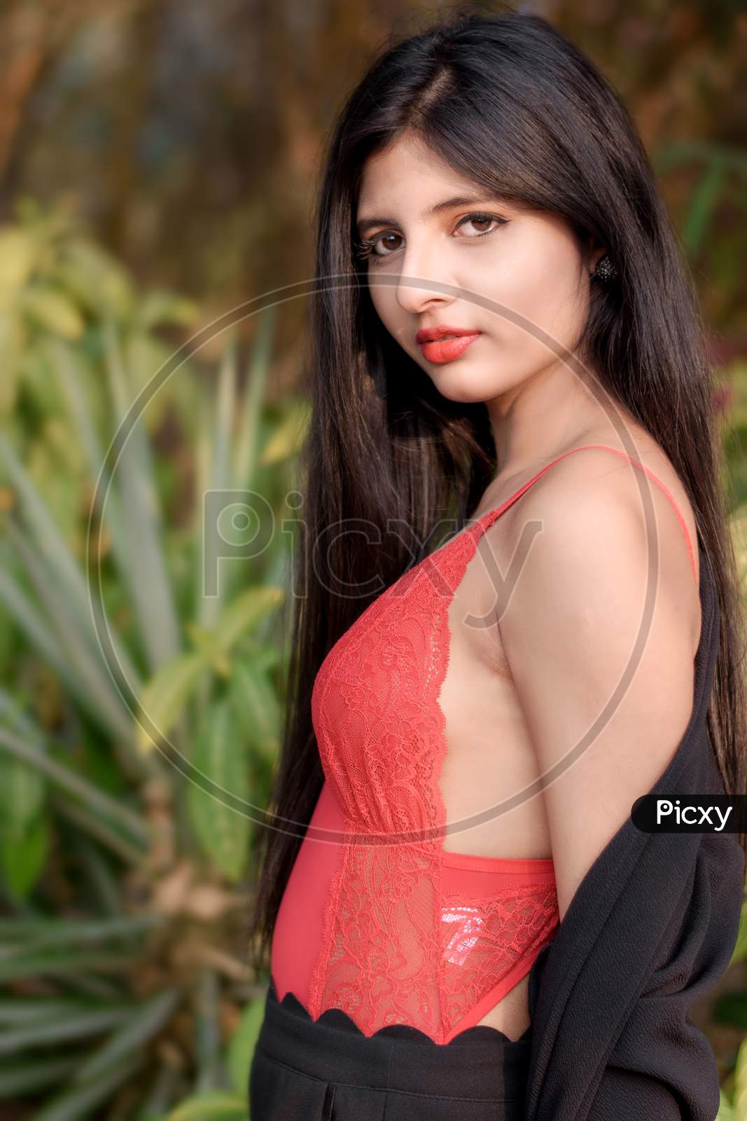 Portrait Of Very Beautiful Young Attractive Woman Wearing Red Outfit With Black Jacket Posing Fashionable In A Blurred Background. Lifestyle And Fashion.