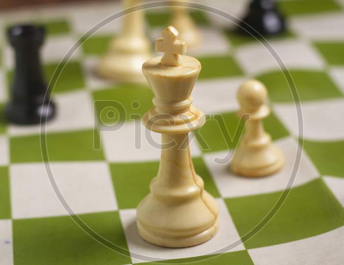 One Side Light On White King Chess Piece. Close Up Photo