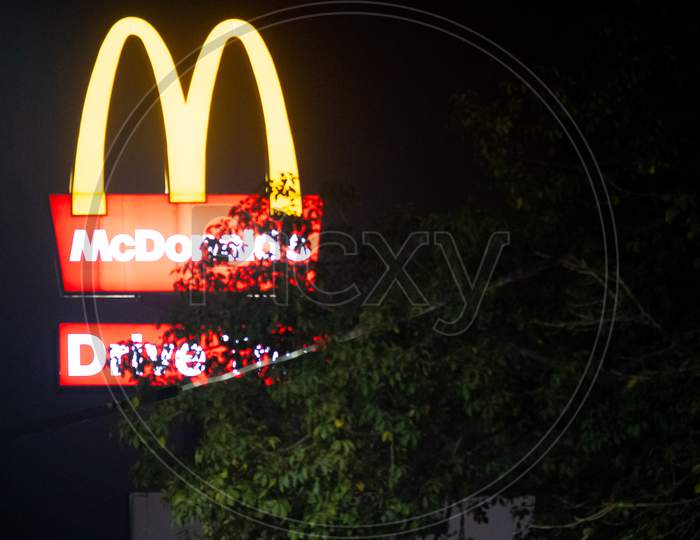 Lit Mcdonalds Golden Arches Shot Through Trees Against The Night Sky Showing This Famous Fast Food Franchise In India