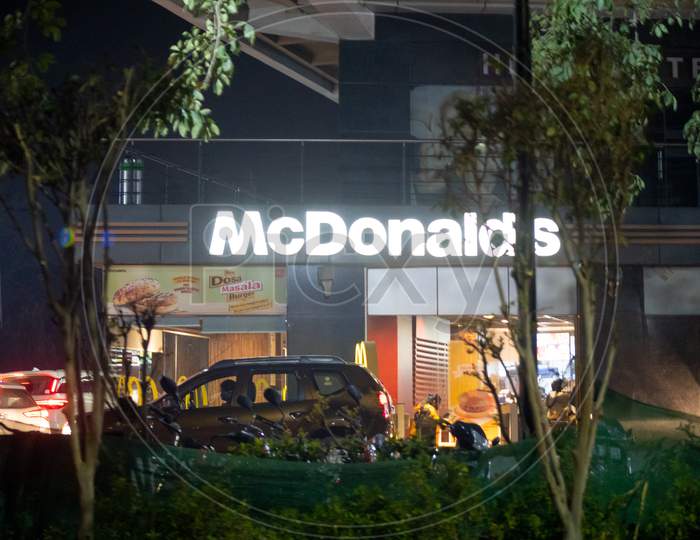 Night Shot Of Lit Mcdonalds Outlet At Night Showing Cars Lining Up In Front For Burgers From This Quick Service Restaurant