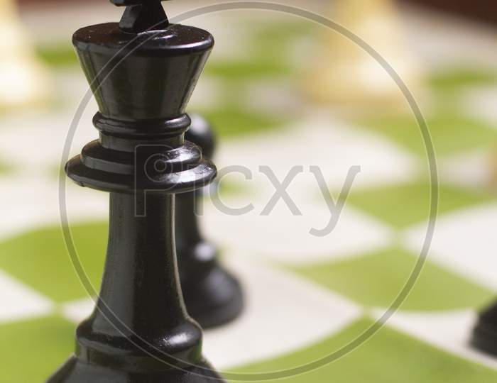 One Side Light On Black King Chess Piece. Close Up Photo