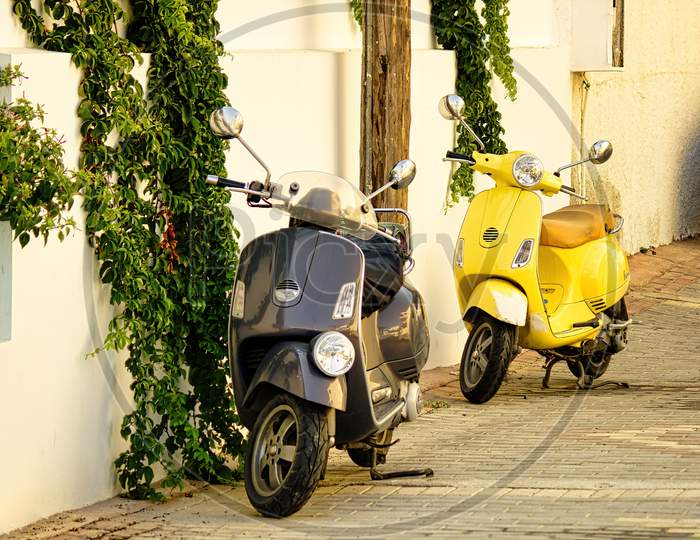 Crete, Greece - September 10, 2017: Vintage Old 2 Wheeler Scooter Of Different Color Parked Next To Wall. Retro Scooter Parked On A Street.