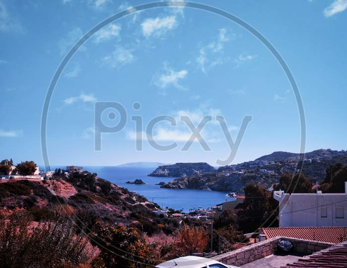 Crete, Greece: A View Near Stalida Beach Of Blue Mediterranean Sea Against Rocky Mountain. Crete Seascape Against Dramatic Clouds